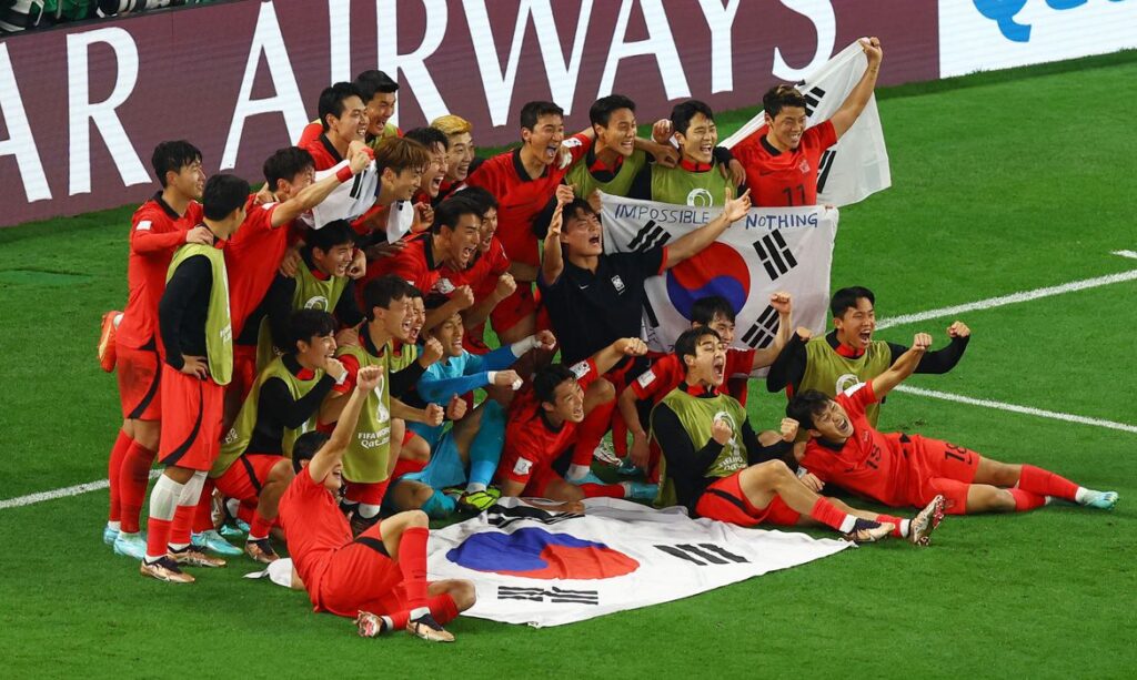 Coreanos posam para a foto da classificação após vitória sobre Portugal. (REUTERS)